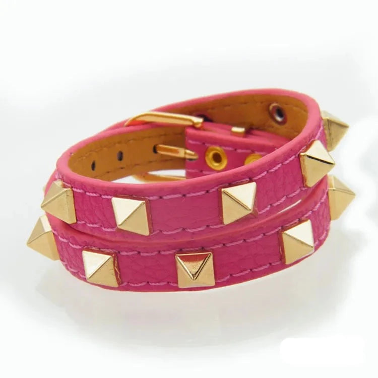 Nitarmband i rosa med guldfärgade nitar